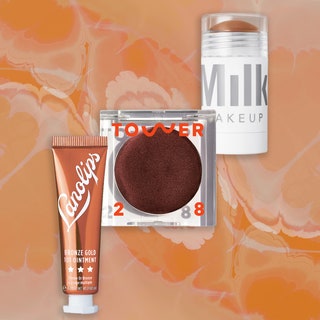 Lano, Tower 28, and Milk Makeup bronzers in a diagonal row on a tan swirly background