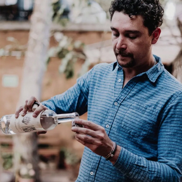 Airbnb Online Experiences for Father's Day: a man pouring mezcal into a glass for the “All About Mezcal with a Oaxaca Sommelier" class