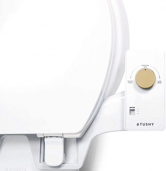 A white Tushy Classic 3.0 Bidet Attachment with a bamboo knob attached to a white toilet on white background